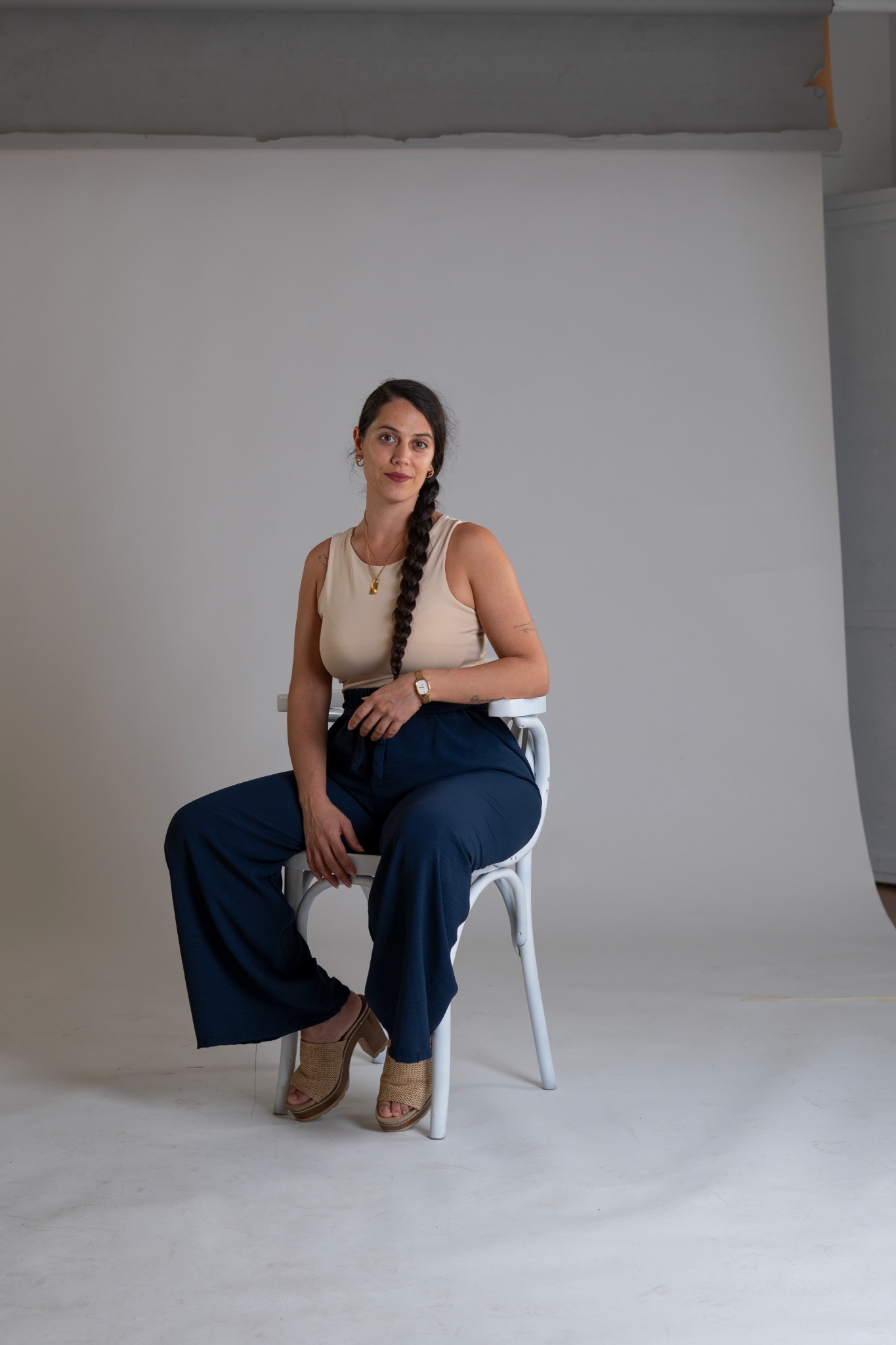 Jenifer Verdú sentada con pantalón azul y blusa marfil, mirando a cámara